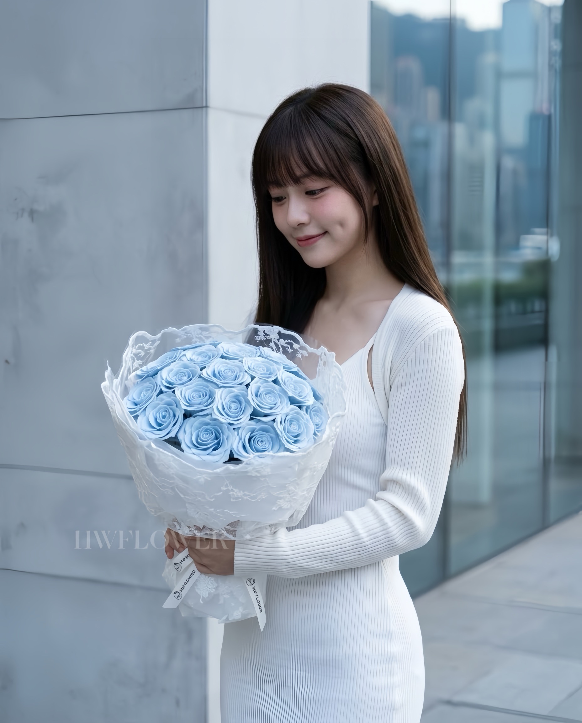 A woman holding a dusty blue soap rose bouquet wrapped in delicate lace fabric.